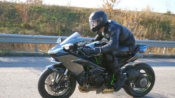 Young Man in Helmet Riding on Modern Sport Motorbike