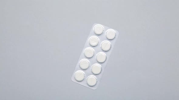 Stop Motion medical pills on grey background.