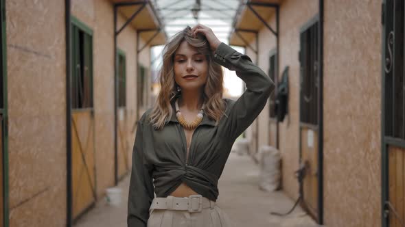 Trendy Lady Disheveling Hair in Stable