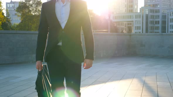 Young Businessman with a Briefcase Walking in City Street. Business Man Commuting To Work in the