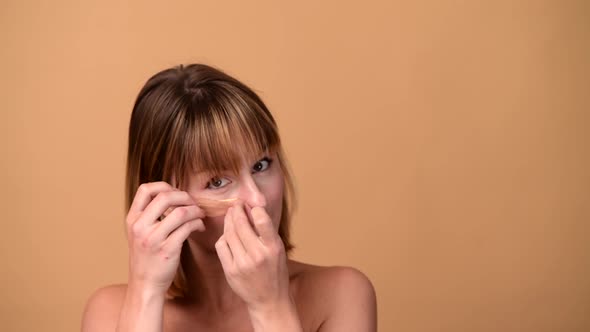 Beautiful Smiling Woman with Short Hair in Gold Eye Patches Looking in Camera and Smiling Over