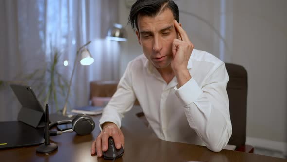 Concentrated Middle Eastern Man Looking at Camera Moving Computer Mouse with Hand