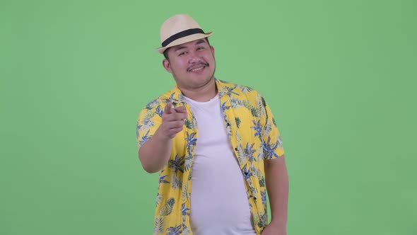 Happy Young Overweight Asian Tourist Man Pointing at Camera