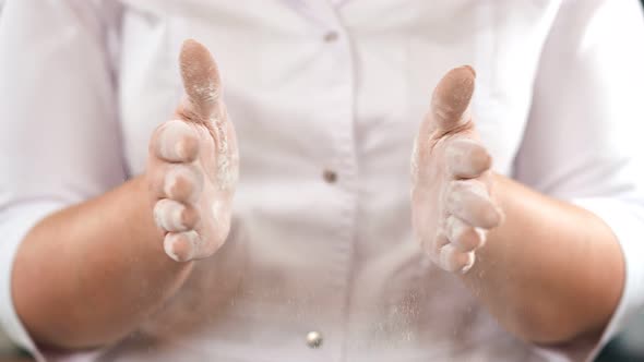 Female in White Uniform Clapping Hands Covered By Flour Slow Motion