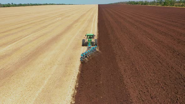 A Tractor Plows a Harvested Corn Field for Future Planting. View From Above