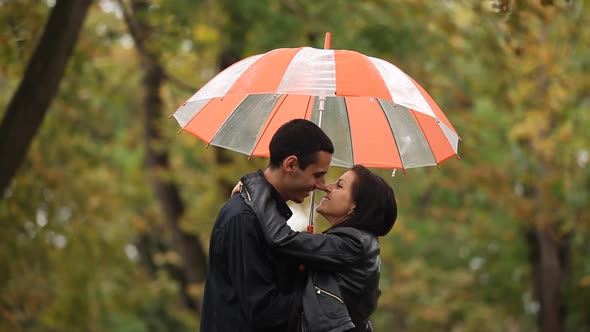 couple with umbrella kissing outdoor in rain in Paris, France