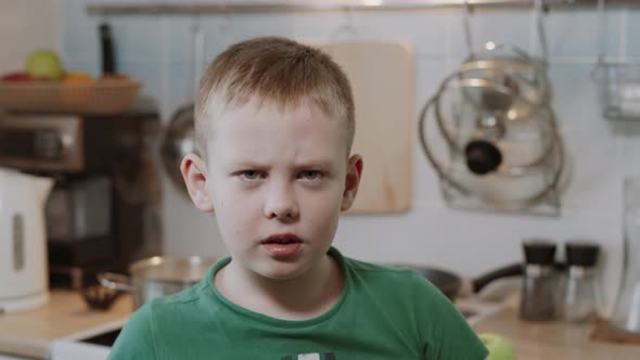 Caucasian Boy is Angry Nervous and Waves His Hands at the Camera in Kitchen