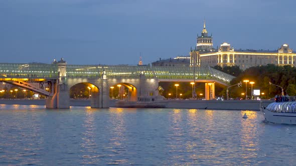 Bridge and Building with Lights and Sailing Ship at Night