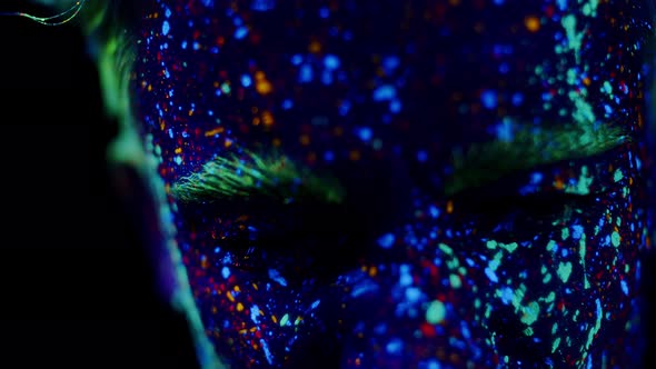 Closeup of Man's Face in Nightclub Painted with Bright Glowing Ultraviolet Paints Front View