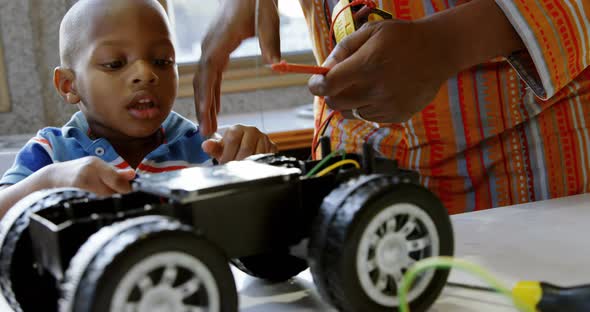 Father and son repairing toy car in a comfortable home 4k