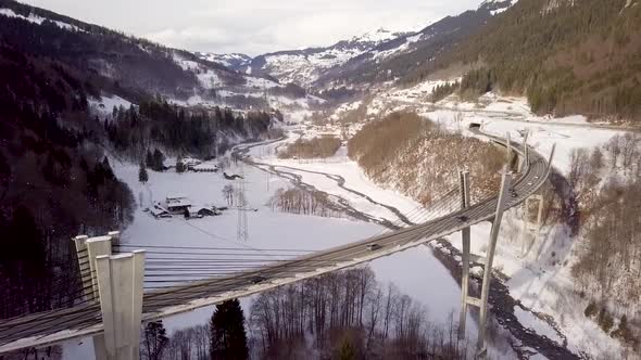 Panorama shot of a very high and curvy bridge in Switzerland. Cars are driving over it.