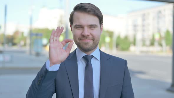 Businessman showing Ok Sign with Finger Outdoor