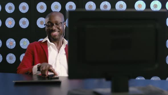 Energetic Africanamerican Man at Desktop Listens to Music and Moves Dancing