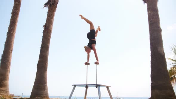 A Young Gymnastic Woman Working Out on the High Beams  Moving Her Legs While Being Upside Down