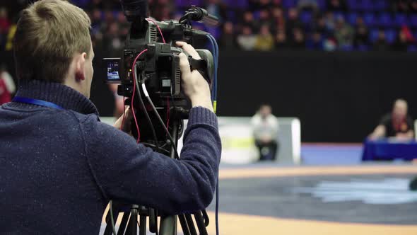 Cameraman with a Camera in Wrestling Competitions. Close-up.