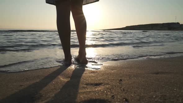 Beautiful Scene of a Woman Walking on Ocean Beach at Sunset