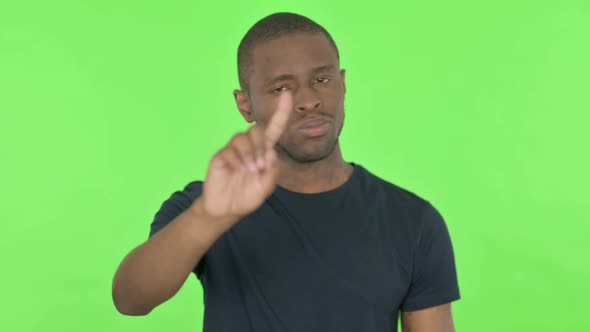 Rejecting Young African Man in Denial on Green Background