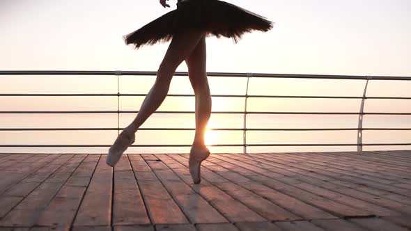 Close Up of an Elegant Ballet Dancer's Legs Stepping on a Wooden Embankment on Tip Toes in Pointes