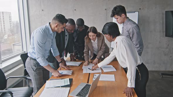 Diverse Multiracial Business Team and Caucasian Woman Mentor Leader Brainstorm Paperwork Talk