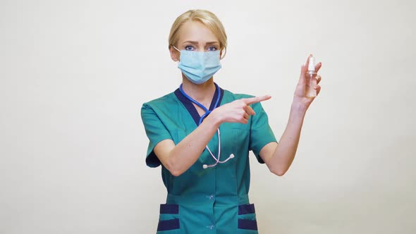 Medical Doctor Nurse Wearing Protective Mask - Holding Bottle of Sanitizing Spray or Gel