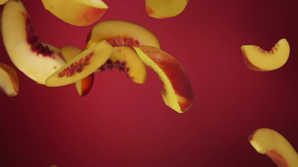 Peach Slices Fly Down on a Red Background