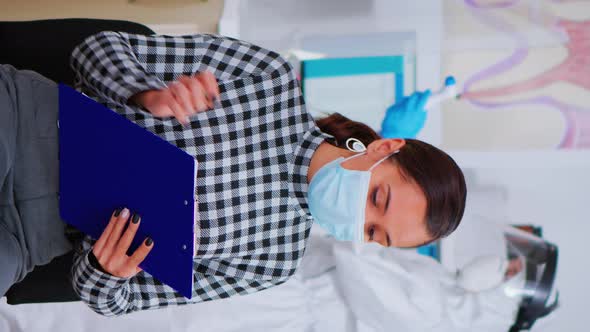 Patient with Face Mask Writing on Registration Form