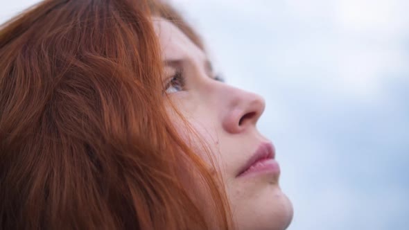 Сlose up Portrait of Beautiful Redhead Woman Exploring Spirituality Looking up Praying 