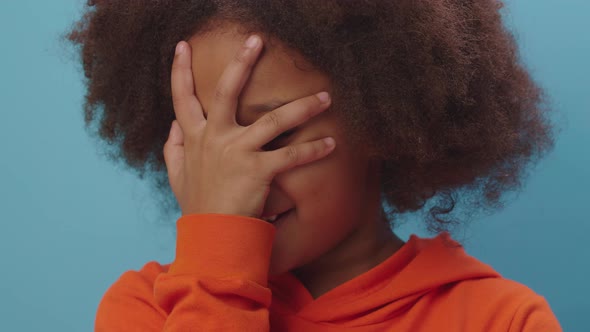 Close up of African American kid makes face palm gesture expressing disbelief, irritation