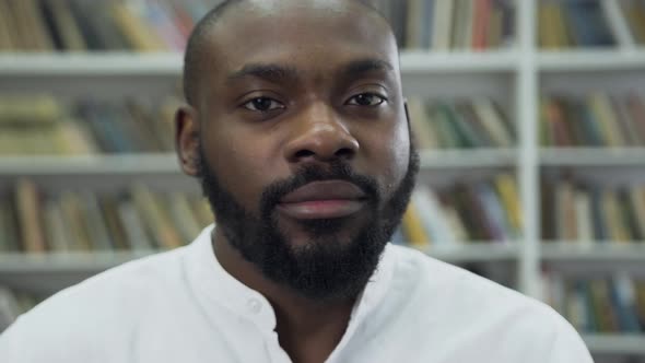 Bearded Black-Skinned Guy which Looking at Camera, Standing in the Library