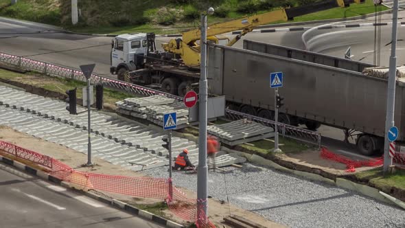 Loader Crane for Loading and Unloading Sleepers From Truck Which Stands on a Road Construction Site