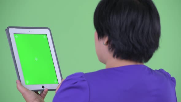 Closeup Rear View of Happy Young Overweight Asian Woman Using Digital Tablet