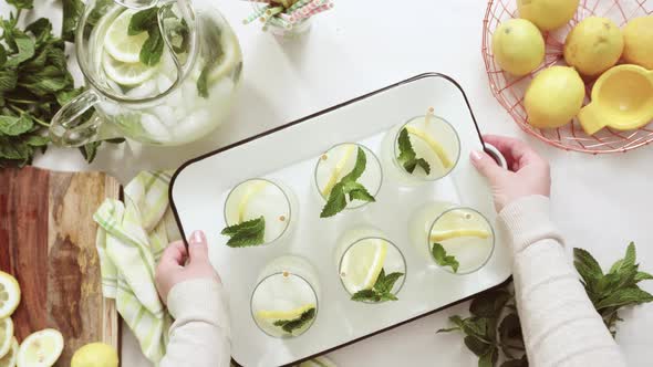 Traditional lemonade with a slice of fresh lemon and mint with paper straw in the glass