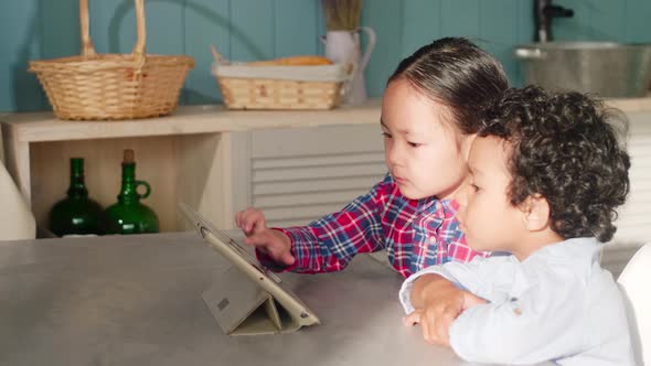 Little Asian Girl and African Boy Using Tablet Together