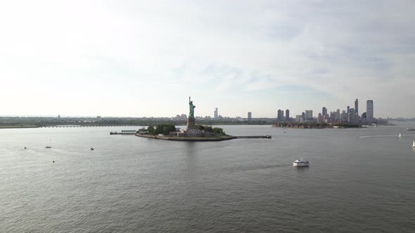 Aerial view of boats and ferries in front of the Liberty island, in New York, USA