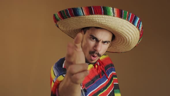 Young Mexican In Multicolored Poncho And Hat