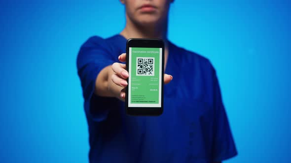 Woman Surgeon in Medical Uniform Showing Vaccination Passport with Qr Code on Phone International