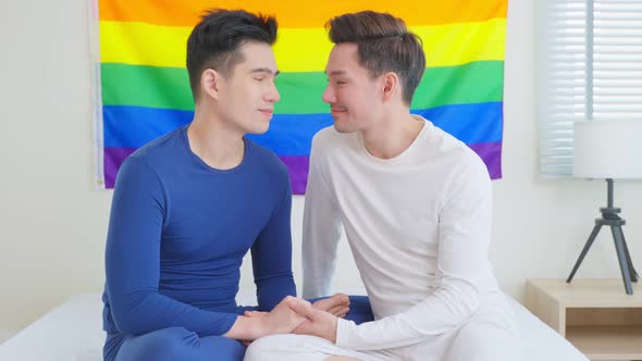 Portrait of Asian handsome man gay family, Confident holding LGBT flag smile and look at camera.