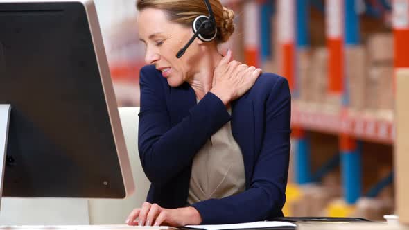 Stressed female warehouse manager working on computer