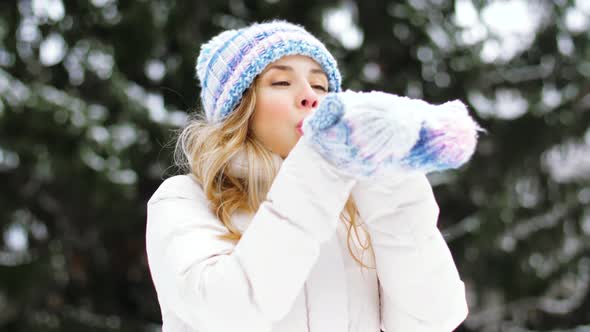 Happy Young Woman Blowing To Snow in Winter Forest 14
