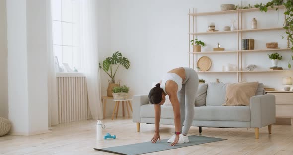 Domestic Stretching Workout. Young Flexible African American Lady Tilting at Home, Reaching To Feet