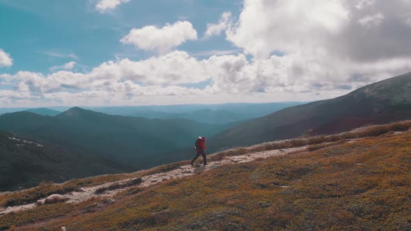 Aerial View of a Traveler with Backpack Climbing Along Mountain Slope. Epic Shot