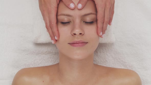 Young, healthy and beautiful woman gets massage therapy in the spa salon.