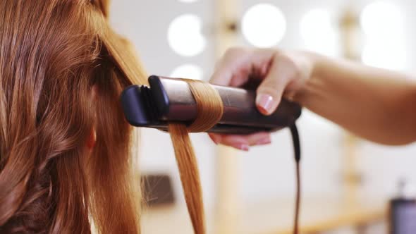 Hairdresser Curling Hair to Foxy Girl in Beauty Salon Close Up Slow Motion