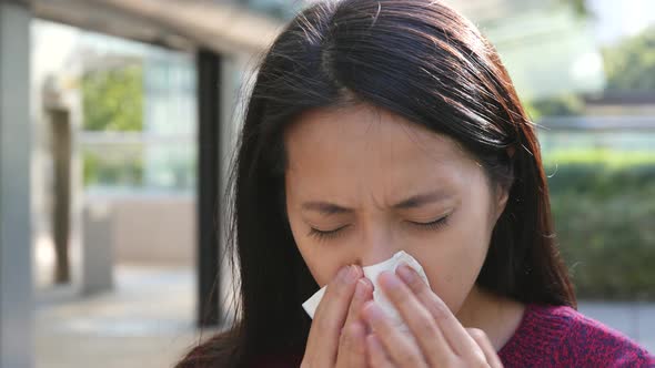 Woman sneeze at outdoor 