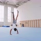 A Teenager Boy Is Doing a Cartwheel and a Triple Back Flip in Gym, Steadicam - VideoHive Item for Sale