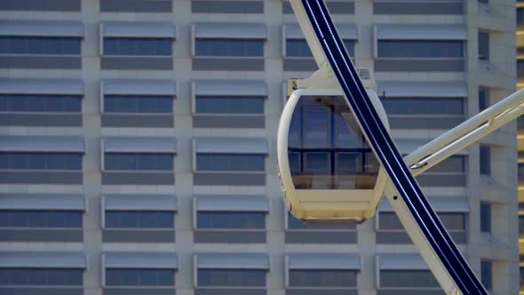 Close up of Ferris Wheel with building in background