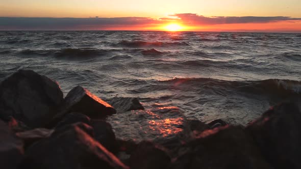 Red Sky Over a Rocky Seashore. Sunset Landscape.