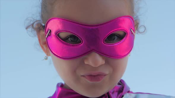 Close Up Portrait Little Girl in the Superhero Costume Dressed in a Pink Cloak