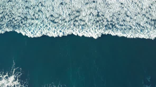 Drone Shot of Foamy Surf Wave Roll Over Water