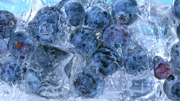 Super Slow Motion Shot of Pouring Water on Blueberries and Ice Cubes in Glass at 1000 Fps